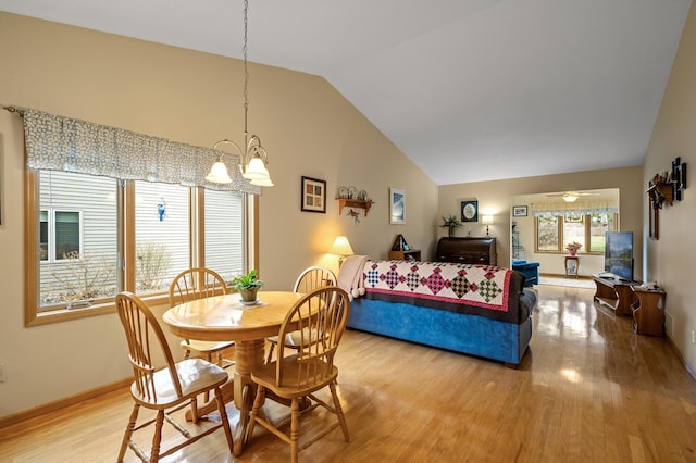553 Cedar Ct, Taylors Falls, MN 55084 - dining room featuring light wood-style floors, vaulted ceiling, baseboards, and ceiling fan with notable chandelier