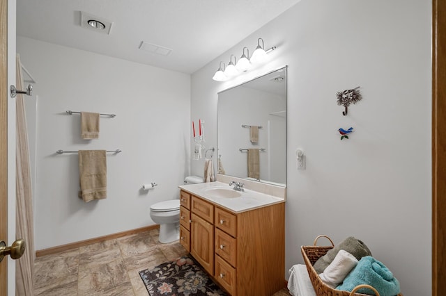 553 Cedar Ct, Taylors Falls, MN 55084 - full bath with stone finish flooring, toilet, vanity, and baseboards