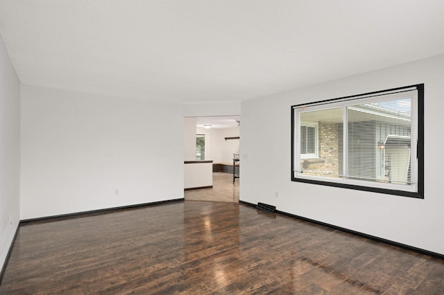 unfurnished room featuring baseboards and wood finished floors