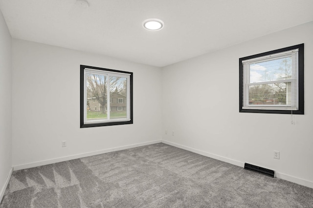 empty room with baseboards, carpet, and visible vents