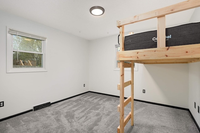 unfurnished bedroom with carpet flooring, baseboards, and visible vents
