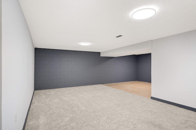 unfurnished room featuring carpet and concrete block wall