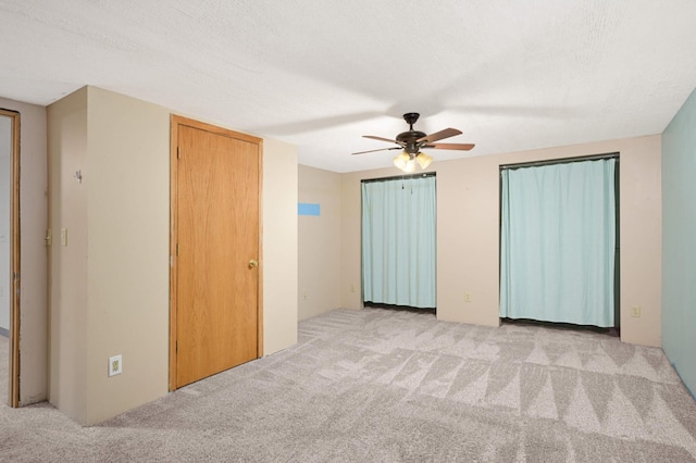 unfurnished bedroom with carpet floors and a ceiling fan