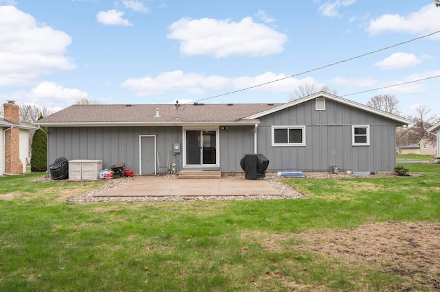 rear view of property featuring a lawn, board and batten siding, and a patio area