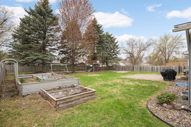 view of yard featuring a fenced backyard, a playground, and a garden