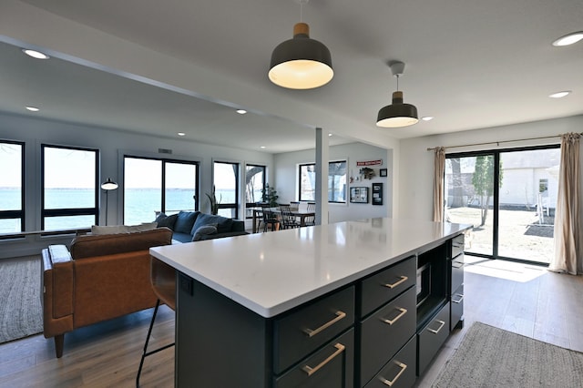 1011 Burgs Park Dr, Shell Lake, WI 54871 - kitchen featuring light countertops, a breakfast bar, wood finished floors, a kitchen island, and hanging light fixtures