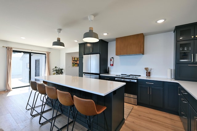 1011 Burgs Park Dr, Shell Lake, WI 54871 - kitchen with stainless steel range with electric stovetop, a breakfast bar, light wood-type flooring, light countertops, and freestanding refrigerator