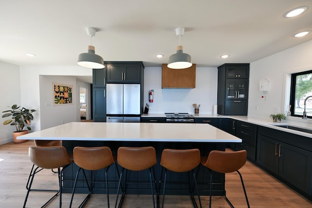 1011 Burgs Park Dr, Shell Lake, WI 54871 - kitchen with light countertops, stainless steel refrigerator, a sink, a center island, and a kitchen bar