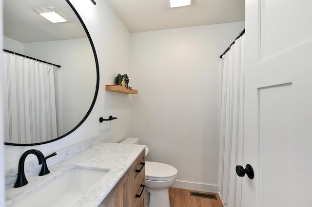1011 Burgs Park Dr, Shell Lake, WI 54871 - full bath featuring wood finished floors, visible vents, toilet, vanity, and baseboards