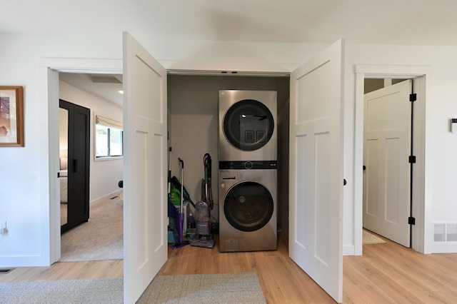 1011 Burgs Park Dr, Shell Lake, WI 54871 - clothes washing area with baseboards, visible vents, light wood-style floors, stacked washer / dryer, and laundry area