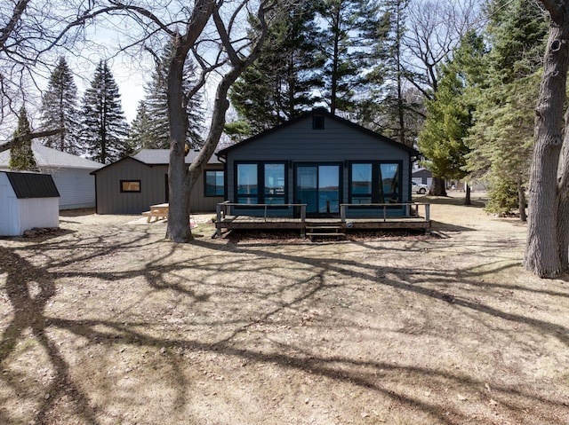 1011 Burgs Park Dr, Shell Lake, WI 54871 - rear view of house featuring a storage shed, a wooden deck, and an outdoor structure