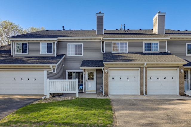 8397 Corcoran Cir Unit 26, Inver Grove Heights, MN 55076 - view of property featuring driveway, a garage, a shingled roof, and a chimney