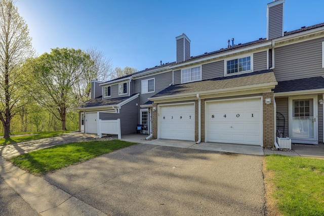 8397 Corcoran Cir Unit 26, Inver Grove Heights, MN 55076 - view of property featuring a chimney, brick siding, and driveway