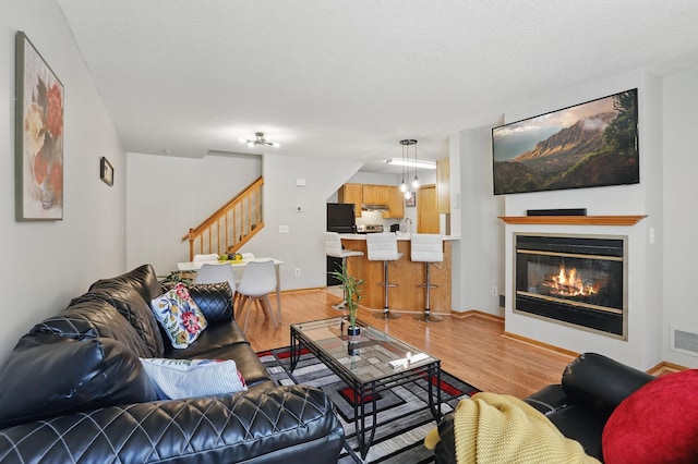 8397 Corcoran Cir Unit 26, Inver Grove Heights, MN 55076 - living area featuring stairway, light wood-style floors, and a glass covered fireplace