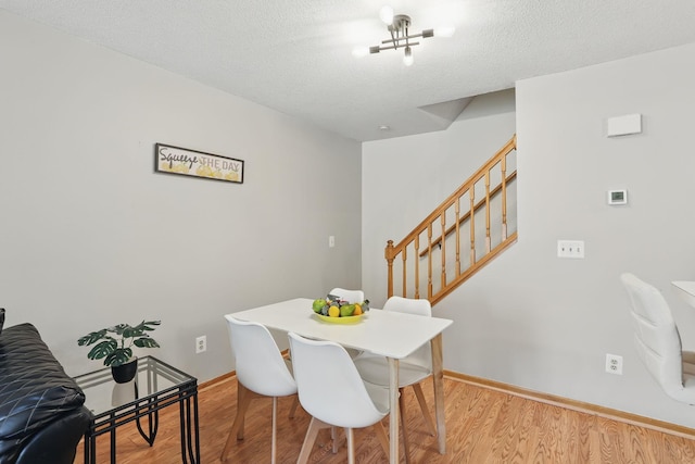 8397 Corcoran Cir Unit 26, Inver Grove Heights, MN 55076 - dining space featuring stairway, light wood-style flooring, baseboards, and a textured ceiling