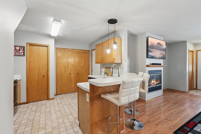 8397 Corcoran Cir Unit 26, Inver Grove Heights, MN 55076 - kitchen featuring light countertops, a peninsula, a textured ceiling, a breakfast bar, and light flooring