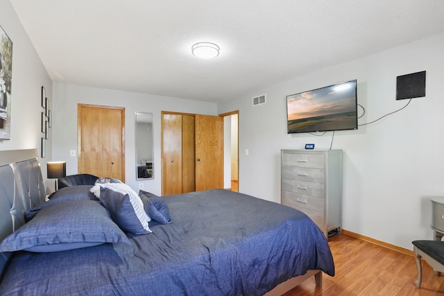 8397 Corcoran Cir Unit 26, Inver Grove Heights, MN 55076 - bedroom featuring light wood finished floors, multiple closets, and baseboards