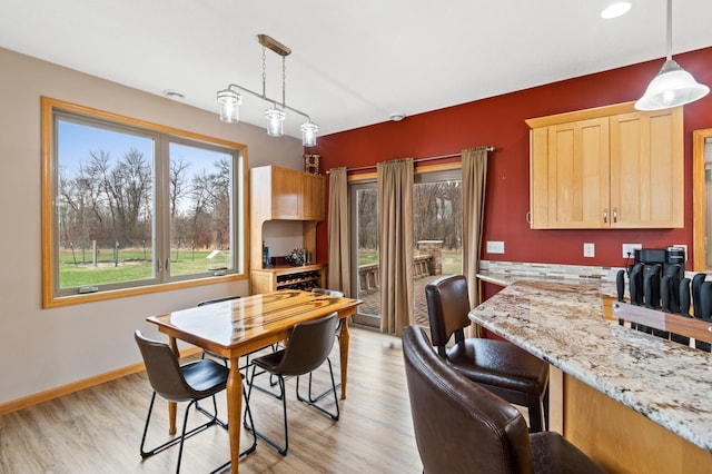 dining room featuring baseboards and light wood-style flooring
