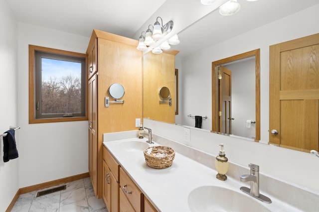 full bathroom with baseboards, visible vents, marble finish floor, and a sink