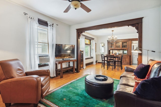 3304 Longfellow Ave, Minneapolis, MN 55407 - living room with radiator heating unit, ceiling fan with notable chandelier, and light wood-style flooring