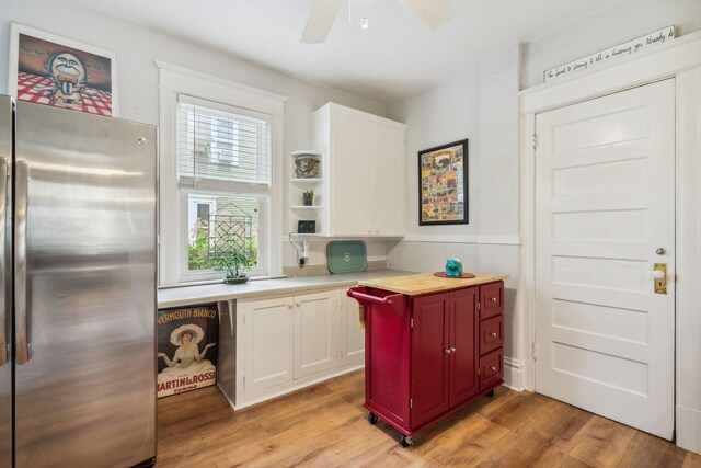 3304 Longfellow Ave, Minneapolis, MN 55407 - kitchen with freestanding refrigerator, light countertops, white cabinets, built in study area, and light wood finished floors