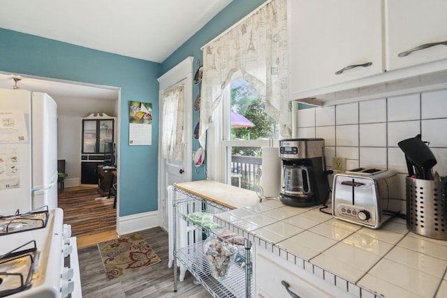 3304 Longfellow Ave, Minneapolis, MN 55407 - kitchen with tasteful backsplash, white cabinetry, tile countertops, white appliances, and wood finished floors