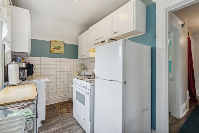 3304 Longfellow Ave, Minneapolis, MN 55407 - kitchen featuring white cabinetry, light countertops, wood finished floors, white appliances, and range hood