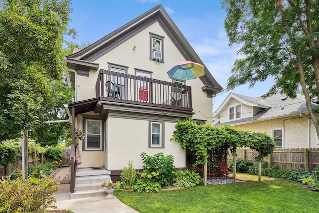 3304 Longfellow Ave, Minneapolis, MN 55407 - rear view of property featuring a balcony, cooling unit, a lawn, stucco siding, and fence
