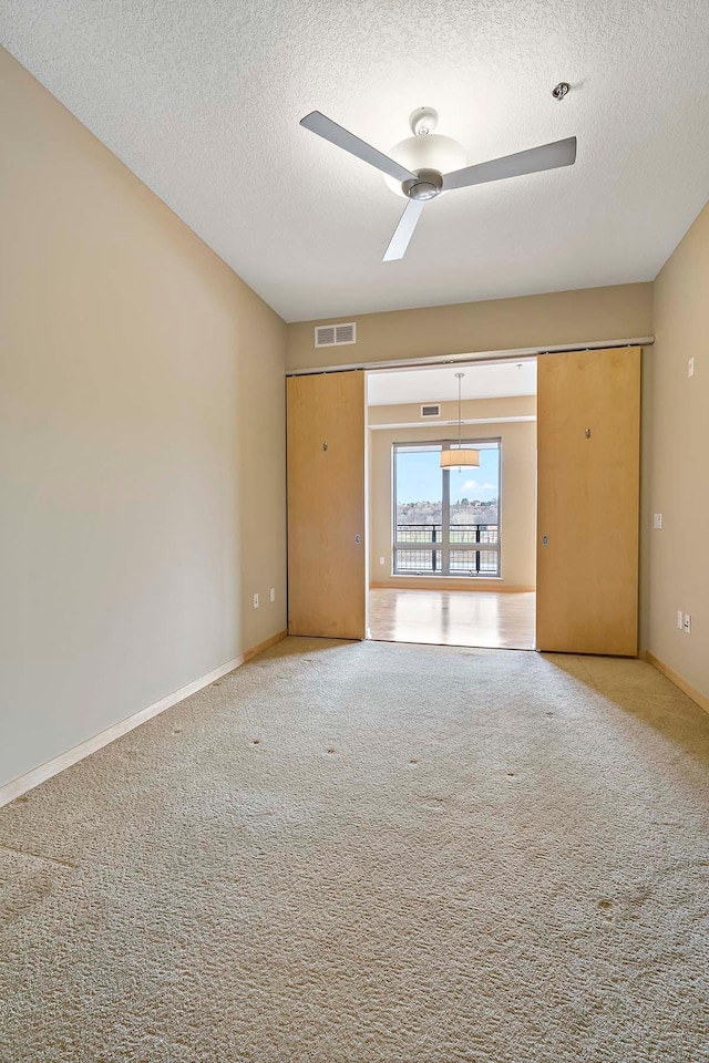 240 Spring St Unit 413, Saint Paul, MN 55102 - unfurnished room featuring a textured ceiling, ceiling fan, carpet flooring, and baseboards