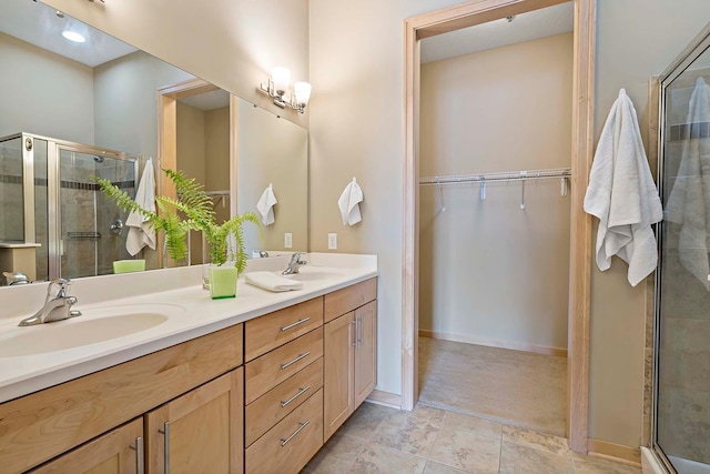 240 Spring St Unit 413, Saint Paul, MN 55102 - full bathroom featuring a shower stall, double vanity, a walk in closet, and baseboards