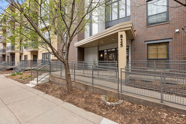 view of front facade with brick siding and fence private yard