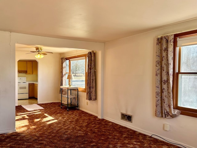 unfurnished living room featuring ceiling fan, carpet, and baseboards