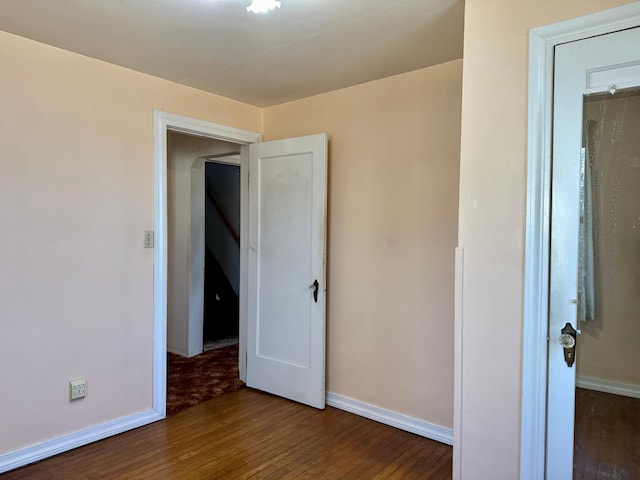spare room with hardwood / wood-style flooring and baseboards