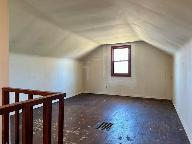 bonus room featuring lofted ceiling, hardwood / wood-style floors, and baseboards