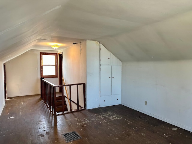 bonus room with hardwood / wood-style floors, lofted ceiling, and baseboards