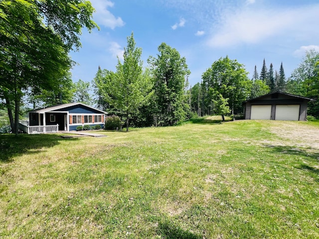 41820 Bald Eagle Dr, Marcell Twp, MN 56628 - view of green lawn featuring an outbuilding, a detached garage, covered porch, and driveway