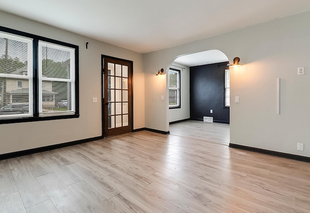 423 1st St NW, Faribault, MN 55021 - spare room with arched walkways, light wood-type flooring, and baseboards