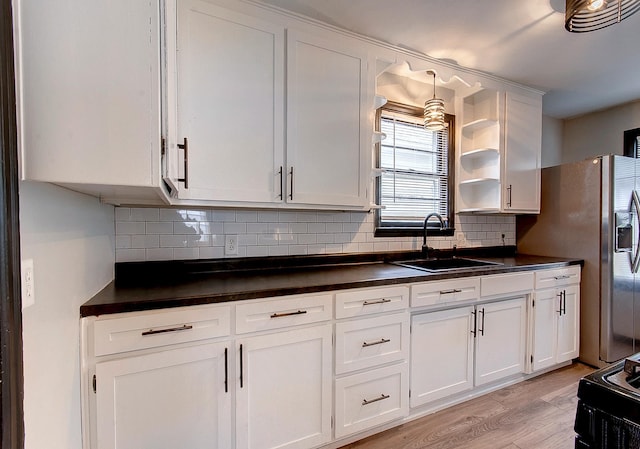 423 1st St NW, Faribault, MN 55021 - kitchen with a sink, dark countertops, white cabinets, and light wood finished floors