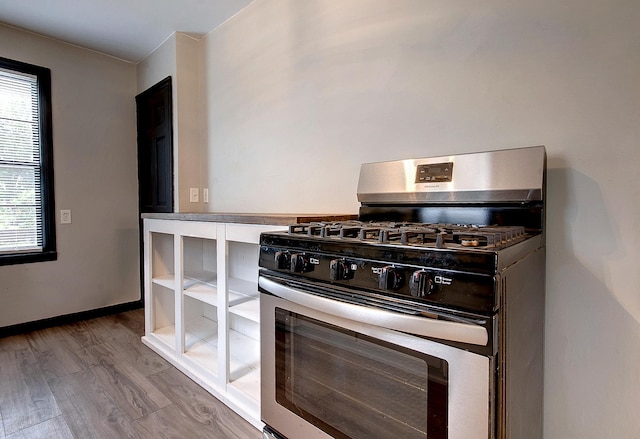 423 1st St NW, Faribault, MN 55021 - kitchen featuring stainless steel gas range oven, wood finished floors, and baseboards