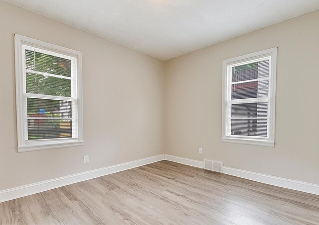423 1st St NW, Faribault, MN 55021 - empty room with light wood finished floors, plenty of natural light, and baseboards