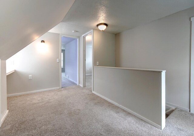 423 1st St NW, Faribault, MN 55021 - bonus room with carpet, vaulted ceiling, baseboards, and a textured ceiling