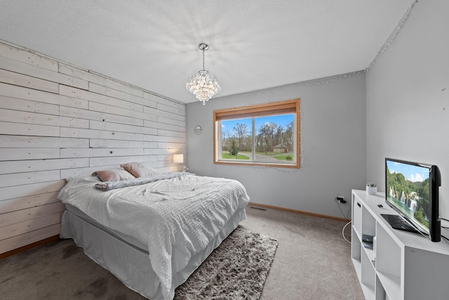 carpeted bedroom featuring a chandelier, wood walls, and baseboards