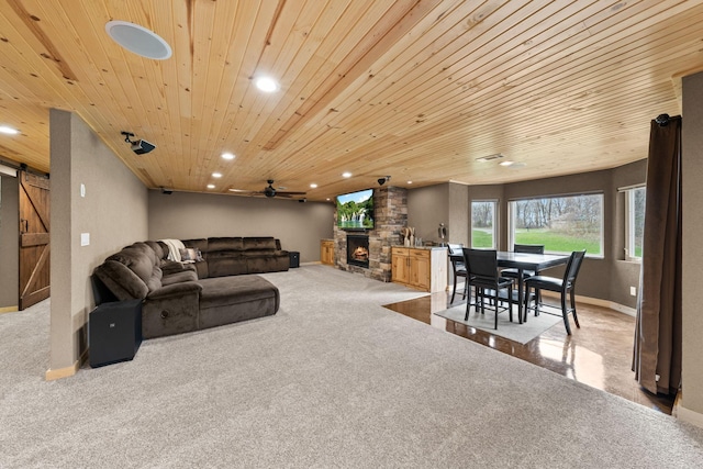 carpeted living area with a barn door, recessed lighting, a ceiling fan, a fireplace, and baseboards