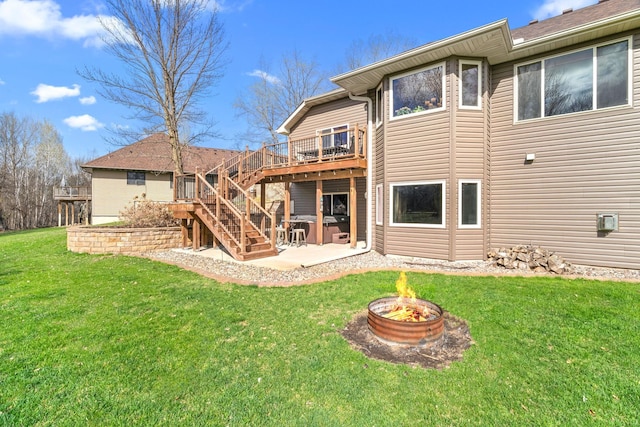 rear view of house featuring a deck, a fire pit, stairs, a patio area, and a lawn