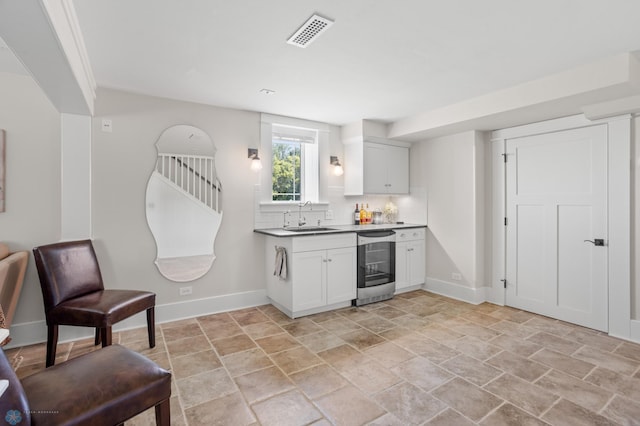 9730 177th Ave SE, Fairmount, ND 58030 - kitchen featuring a sink, dishwashing machine, baseboards, stone finish floor, and visible vents