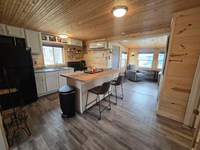 50967 Wymer Lake Trl, Hobart Twp, MN 56544 - kitchen with butcher block countertops, a wall unit AC, black appliances, white cabinets, and wooden ceiling