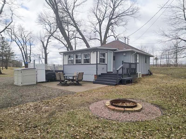 50967 Wymer Lake Trl, Hobart Twp, MN 56544 - rear view of property with an outdoor fire pit, a patio area, central air condition unit, and a lawn