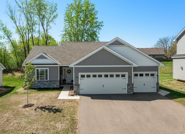 5928 Th St W, Lakeville, MN 55044 - craftsman-style house featuring stone siding, asphalt driveway, a garage, a front yard, and a shingled roof