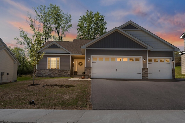 5928 Th St W, Lakeville, MN 55044 - craftsman-style house with stone siding, asphalt driveway, an attached garage, and a front yard