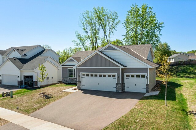 5928 Th St W, Lakeville, MN 55044 - craftsman-style home with asphalt driveway, stone siding, a front yard, and an attached garage